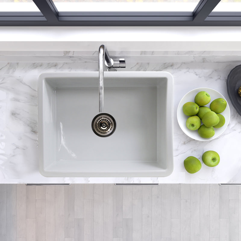 Nantucket Sinks ISFC24W-SB1 white single bowl sink from above in a marble counter with green apples