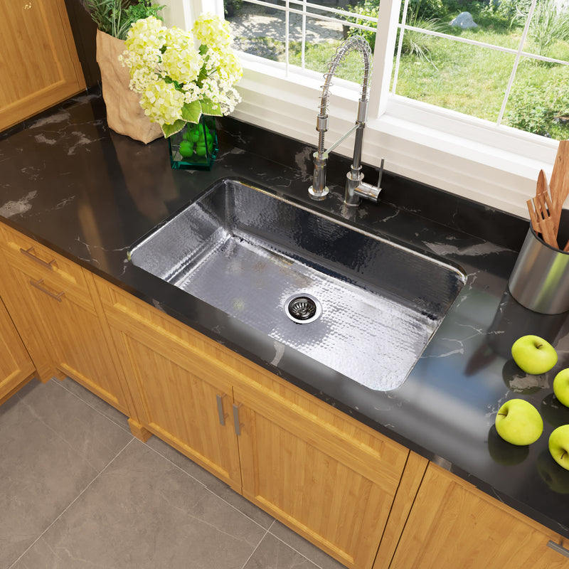 Nantucket Sinks KSSH3219-10 installed in a black counter over wood cabinets with a window