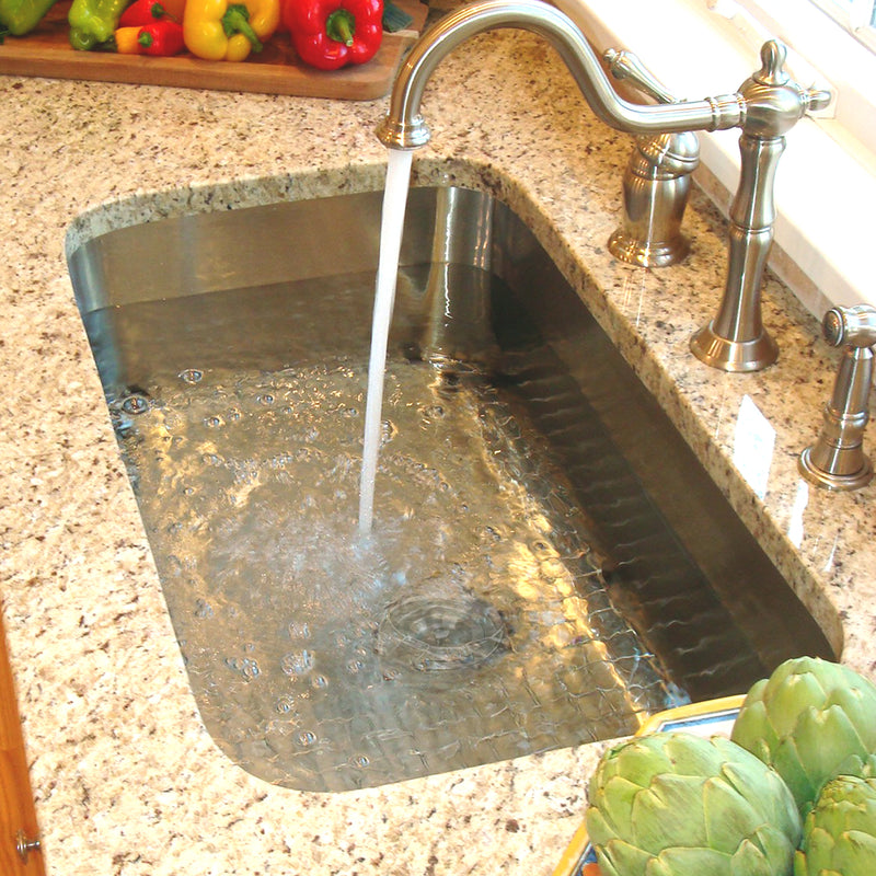 Nantucket Sinks NS3018-9-16 installed in granite with a bridge faucet filling the bowl