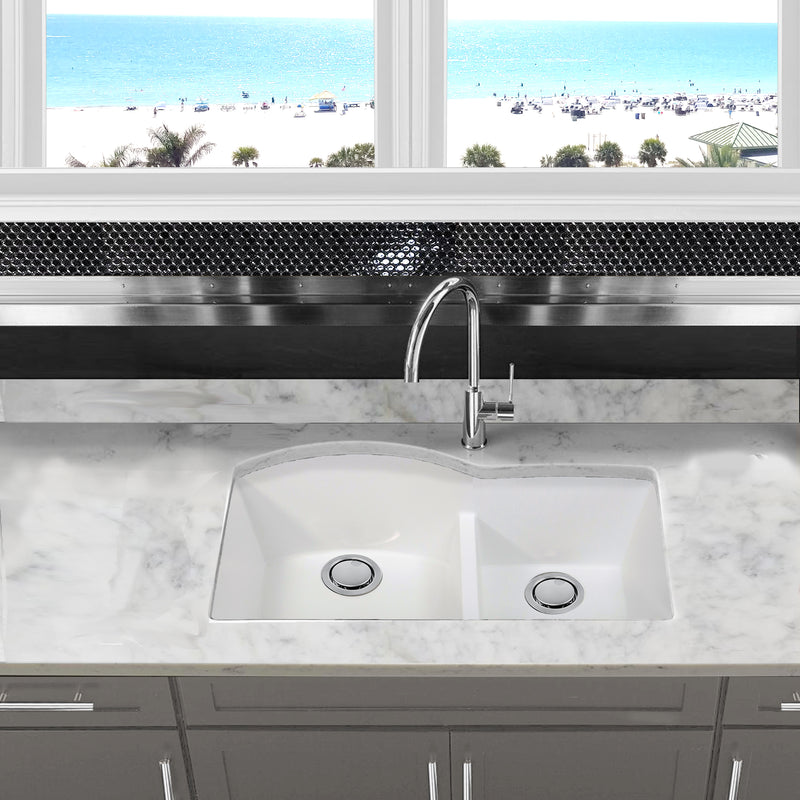 Nantucket Sinks PR6040-W-UM white double bowl sink undermounted in a marble counter under a beach-view window