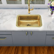 Nantucket Sinks REB2014 hammered brass sink in a white marble counter over gray cabinets, top view