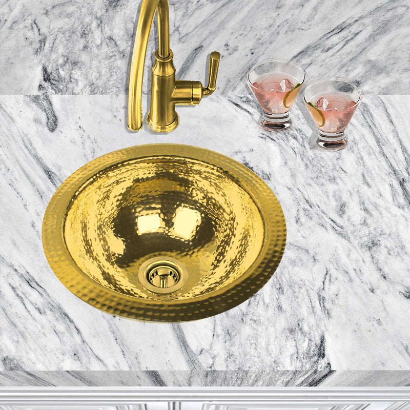 Nantucket Sinks ROB round hammered brass sink in a white marble counter with a brass faucet, top view