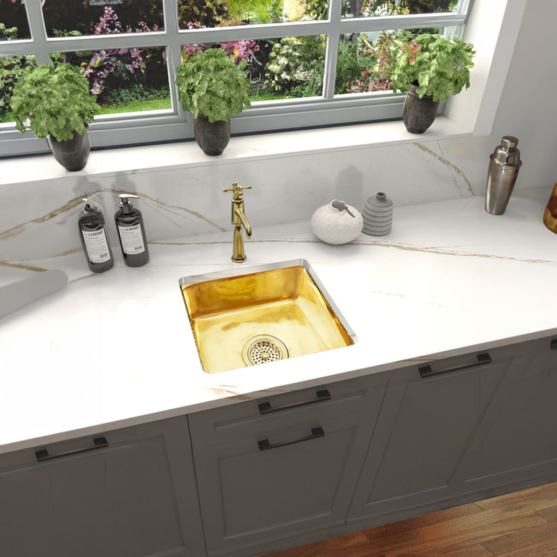 Nantucket Sinks SQRB-7SM smooth brass sink in a white marble counter under a garden window