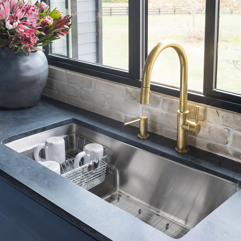 Nantucket Sinks STEPPE3918 installed in dark stone with a brass faucet and basket of mugs
