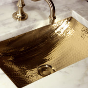 Nantucket Sinks TRB-OF close view of the hammered brass basin and drain under a brass faucet