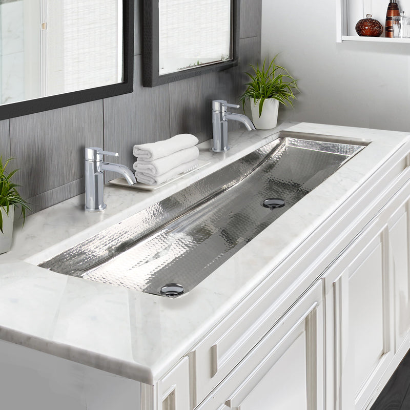 Nantucket Sinks TRS48-OF stainless trough sink undermounted in white marble with two chrome faucets