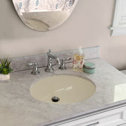Nantucket Sinks UM-15x12-B bisque oval undermount sink in a gray marble vanity with a widespread faucet