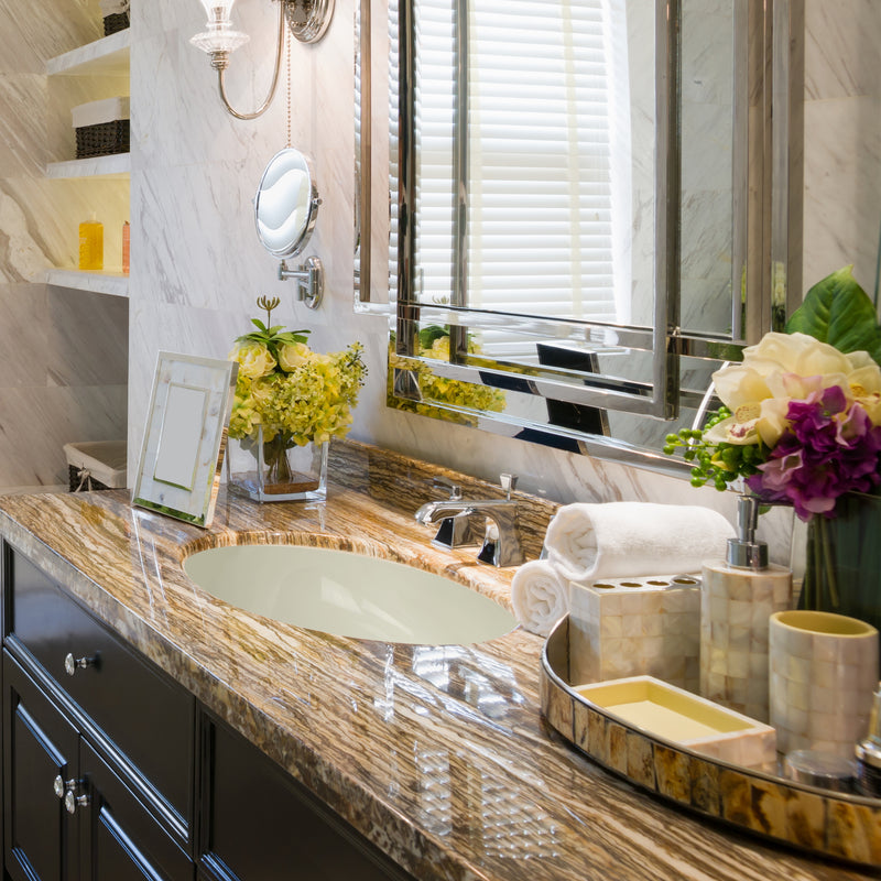 Nantucket Sinks UM-15x12-B bisque oval undermount sink in an onyx vanity top with towels and flowers