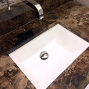 Nantucket Sinks UM-18x13-W white undermount sink in a brown marble vanity with a wall-mount faucet
