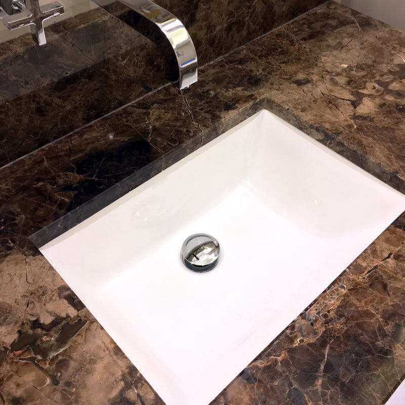 Nantucket Sinks UM-18x13-W white undermount sink in a brown marble vanity with a wall-mount faucet
