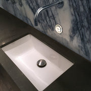 Nantucket Sinks UM-19x11-W white undermount sink in a dark stone counter with a wall-mount faucet