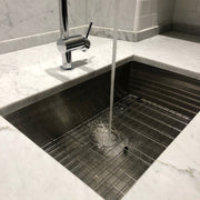 Nantucket Sinks ZR2818-8-16 installed in white marble with grid, water filling the bowl