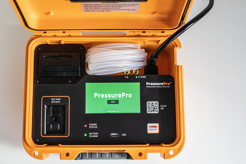 PressurePro recorder from above with the start screen lit, clear pressure tubing and power cord stored in the case
