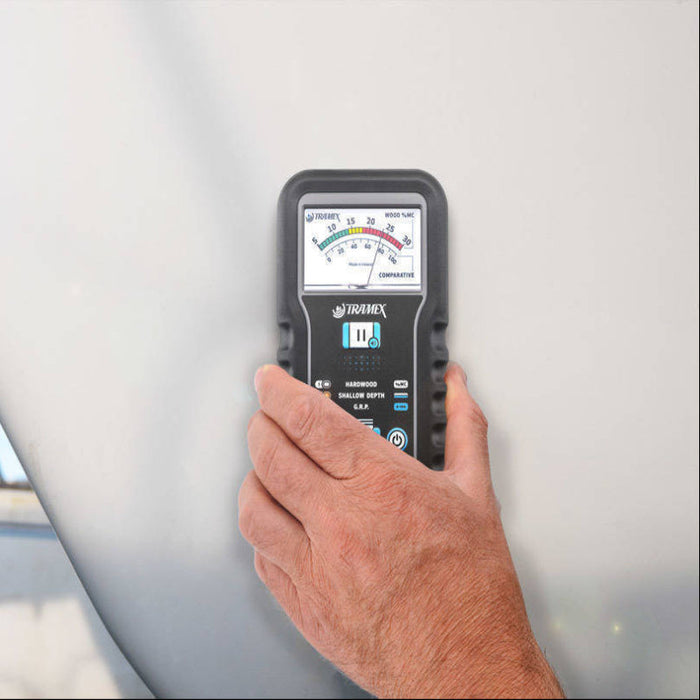 Tramex SMM5 - Skipper 5 Moisture Meter A user holds the Skipper 5 moisture meter against the hull of a boat, demonstrating its use in measuring moisture levels.