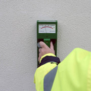 Tramex RWS - Roof and Wall Scanner: Image of the Tramex RWS moisture meter on a flat surface, showcasing its display screen, control buttons, and ergonomic design, designed for detecting moisture levels in roofs and walls.