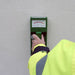 Tramex RWS - Roof and Wall Scanner: Image of the Tramex RWS moisture meter on a flat surface, showcasing its display screen, control buttons, and ergonomic design, designed for detecting moisture levels in roofs and walls.
