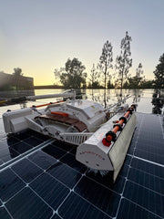Tucker RTM MINI solar cleaning robot on wet rooftop panels at sunset