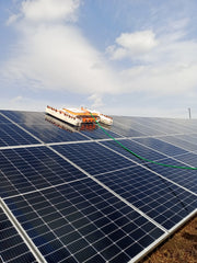 Tucker RTM solar cleaning robot on a ground mounted solar array with its water hose