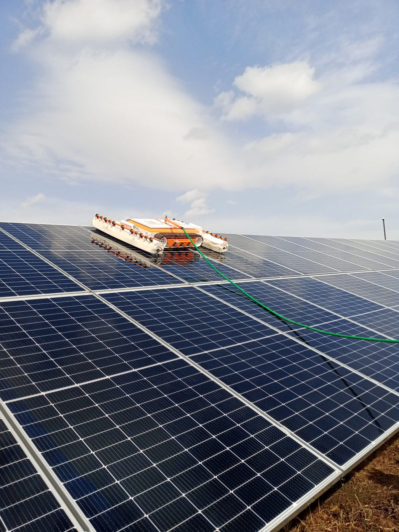 Tucker RTM solar cleaning robot on a ground mounted solar array with its water hose