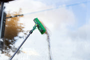 Unger nLITE Power Brush Complete, flagged 11"/28cm, rinsing a window with the brush