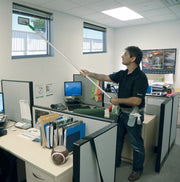 Unger SpeedClean Starter Kit, cleaning a high office partition with the pad holder on a pole